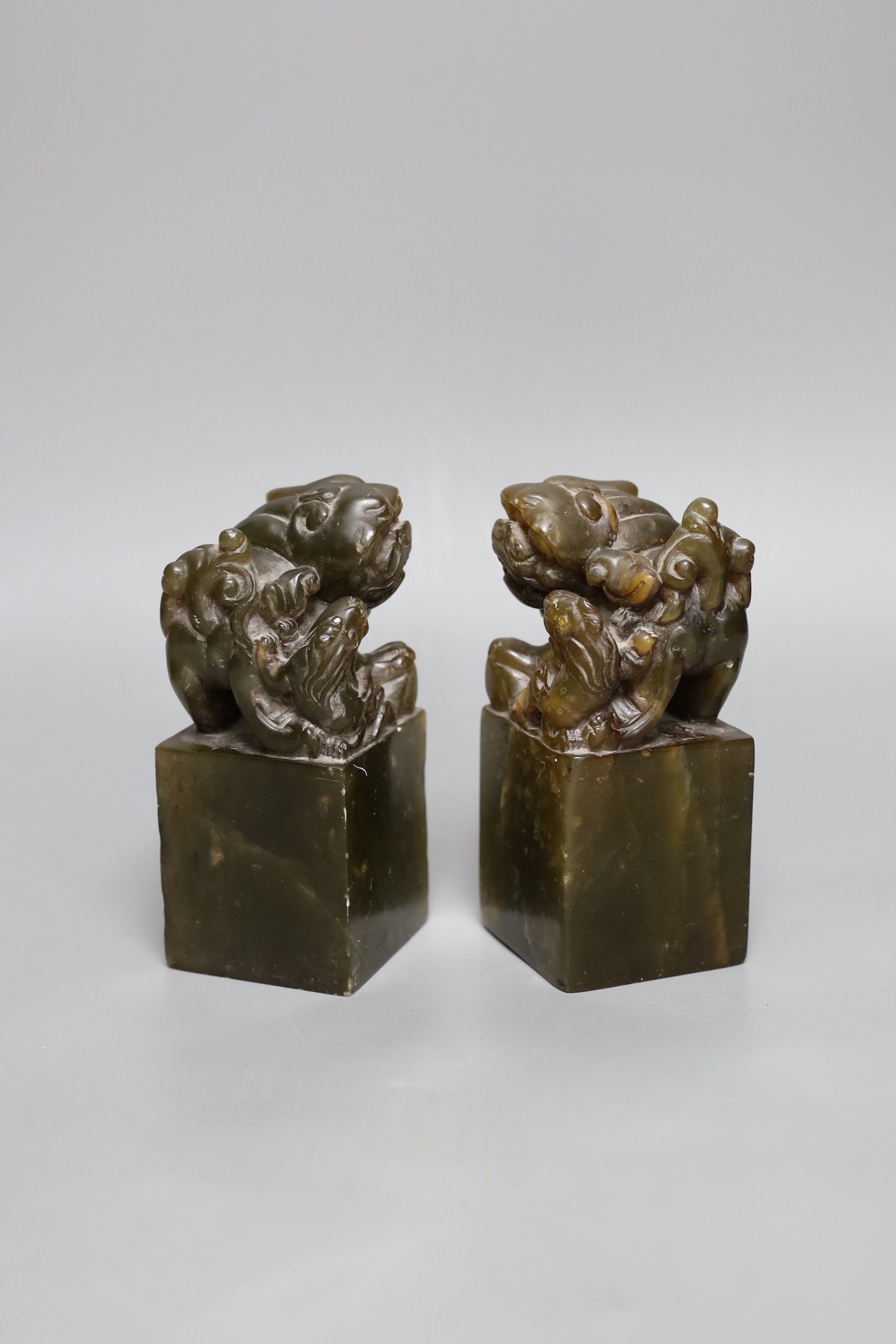 A pair of Chinese soapstone lion dog seals, 15 cms high